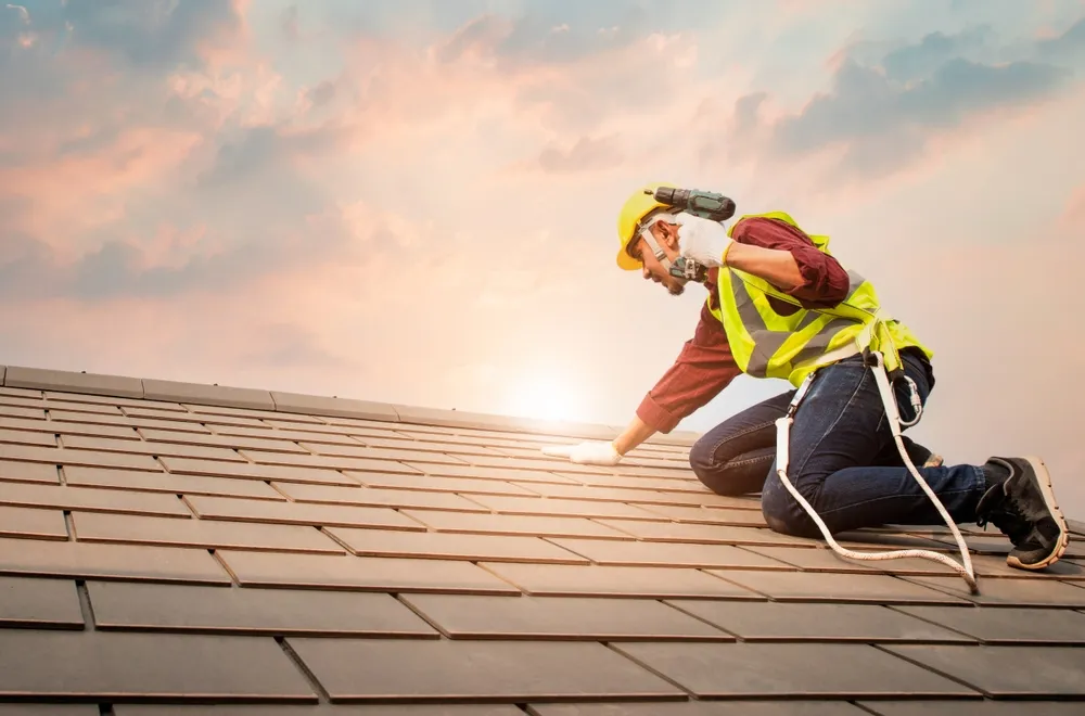 Professional roofer installing shingles at sunset in Charlotte, NC
